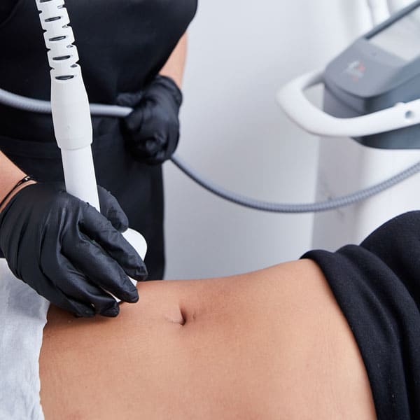 a radio frequency treatment device is being held against a female tummy to perform a body contouring treatment