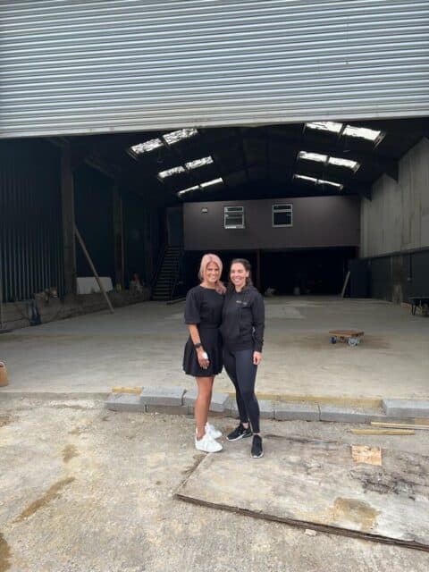 Two women stood outside an empty cow shed