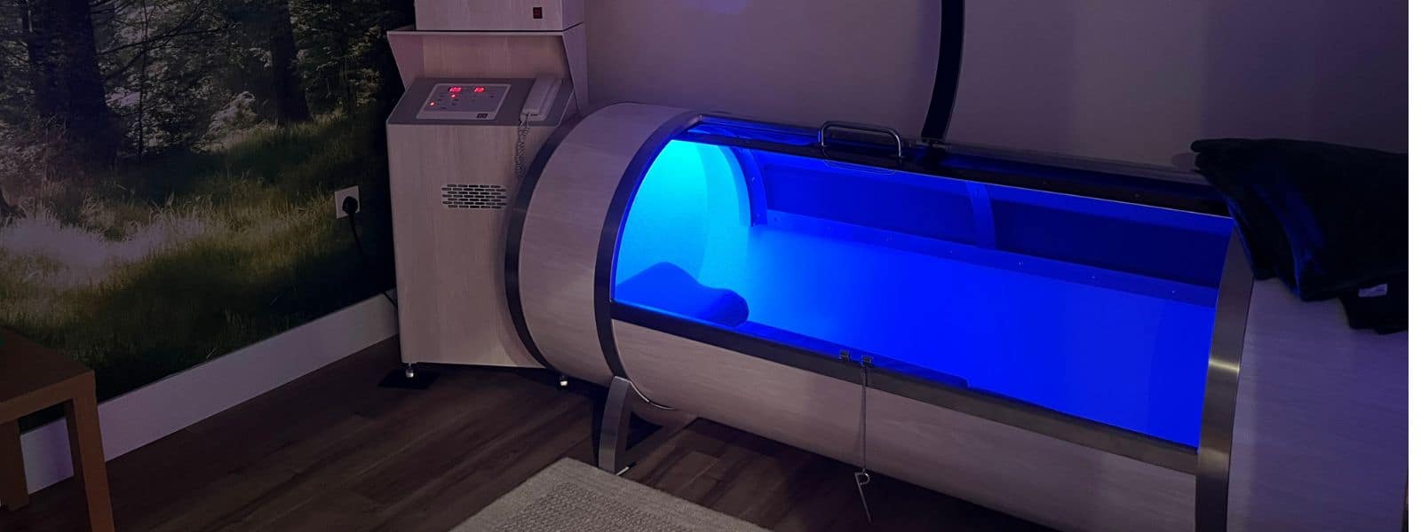 the airpod hyperbaric chamber, a long cylinder shape chamber with a glass lid lit up with blue lighting