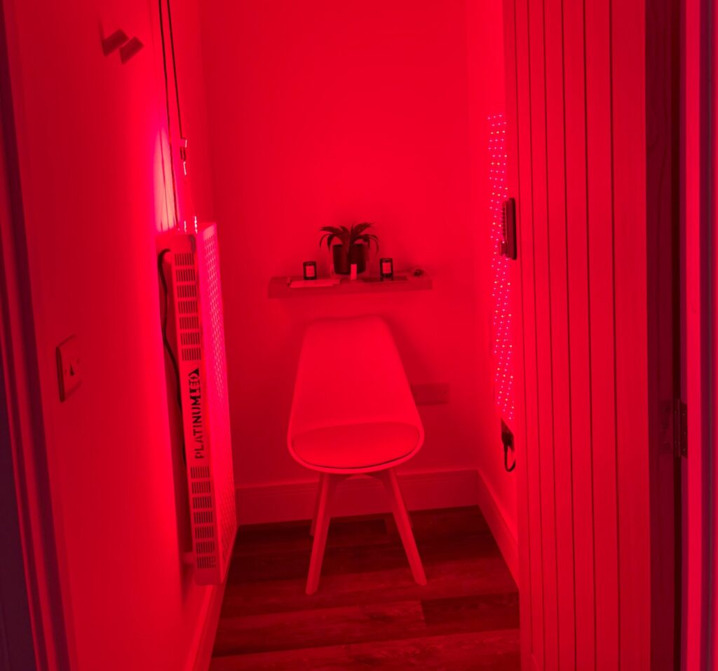 a room with a chair and two red led light therapy panels on either side