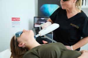 a clearlift laser is held by a therapist treating a female neck