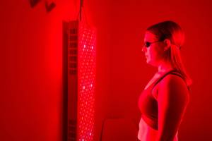 a female stands in front of a red light panel